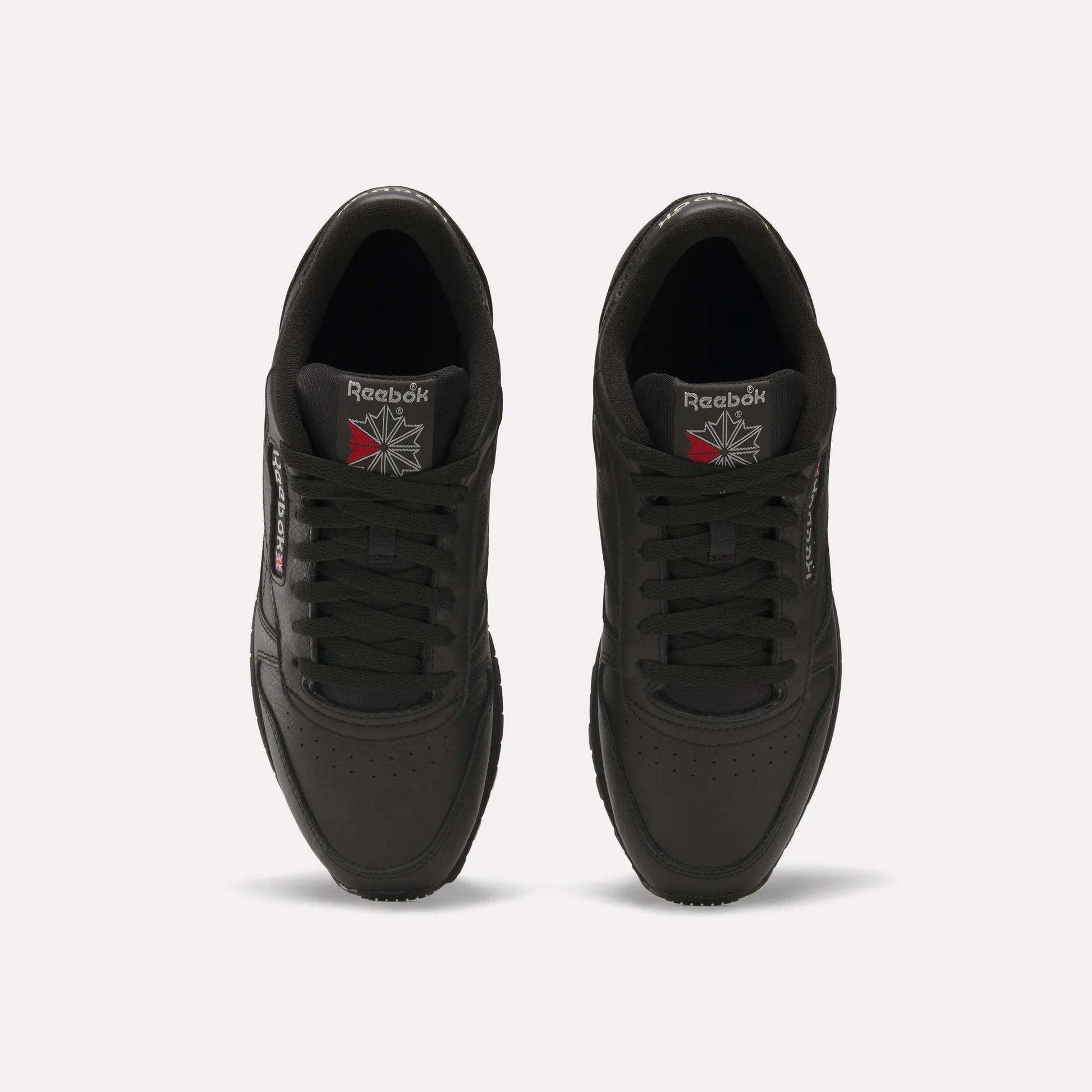 Top view of Reebok Classic Leather Shoes in black, featuring a durable leather upper and iconic Reebok logos on the tongue and side, displayed against a plain white background.