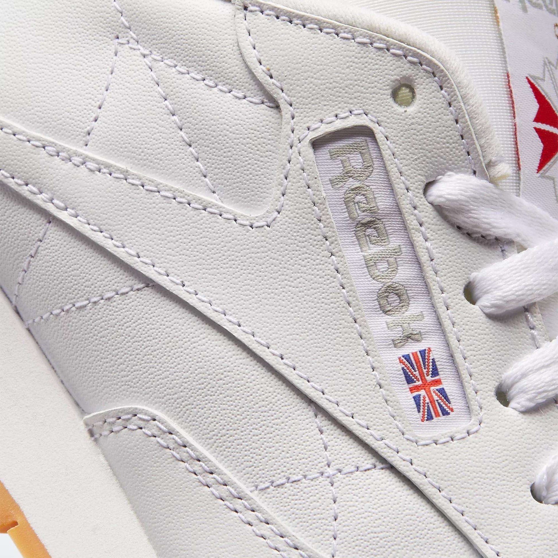 Close-up of Reebok Women's Classic Leather Shoes, highlighting the brand logo, Union Jack patch, white laces, detailed stitching, and cushioned midsole.