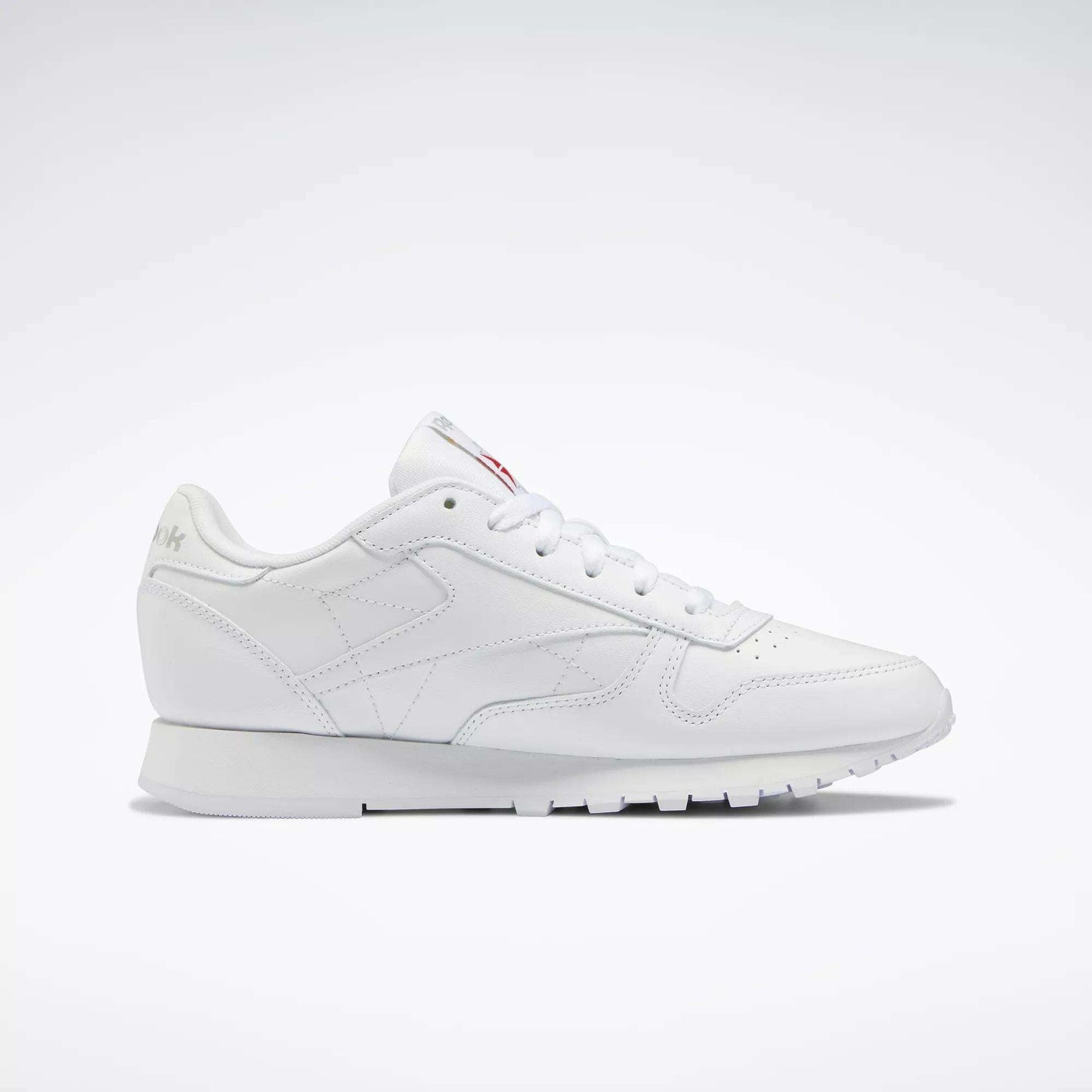 Reebok Women's Classic Leather Shoes feature a low-top design, cushioned midsole, lace-up closure, and subtle side and tongue branding, showcased against a plain white background.