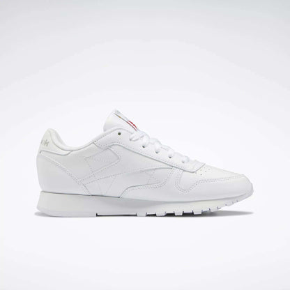 Reebok Women's Classic Leather Shoes feature a low-top design, cushioned midsole, lace-up closure, and subtle side and tongue branding, showcased against a plain white background.