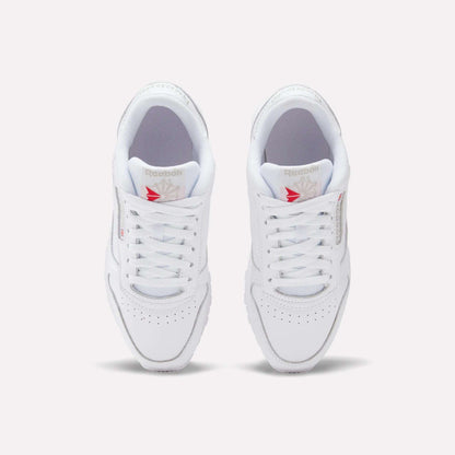 Top view of Reebok Women's Classic Leather Shoes, white leather with cushioned midsole and red star logo on the tongue, shown side by side on a plain white background.
