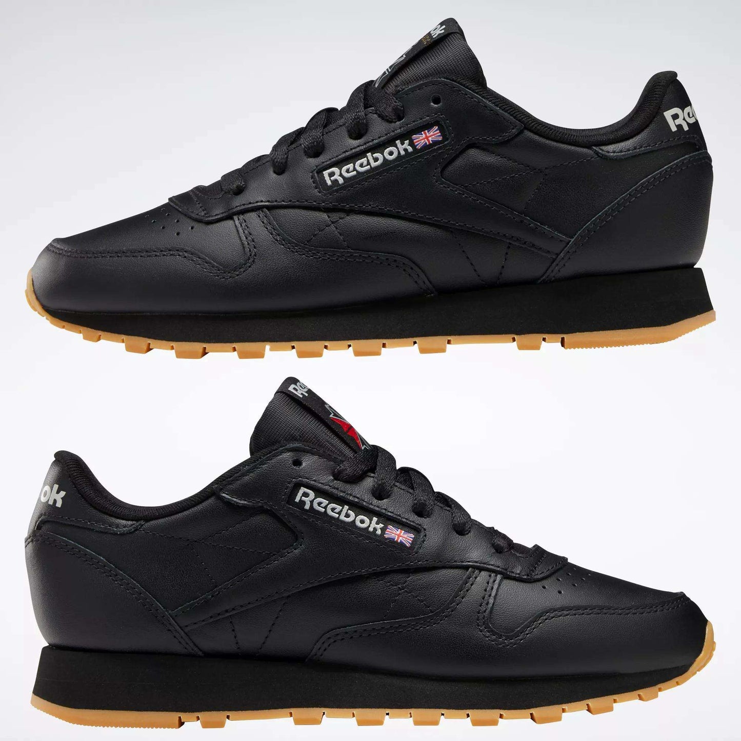A side view of Reebok Women's Classic Leather Shoes in black with gum soles; visible features include cushioned midsoles, Reebok logos, and a small UK flag on the side and heel.
