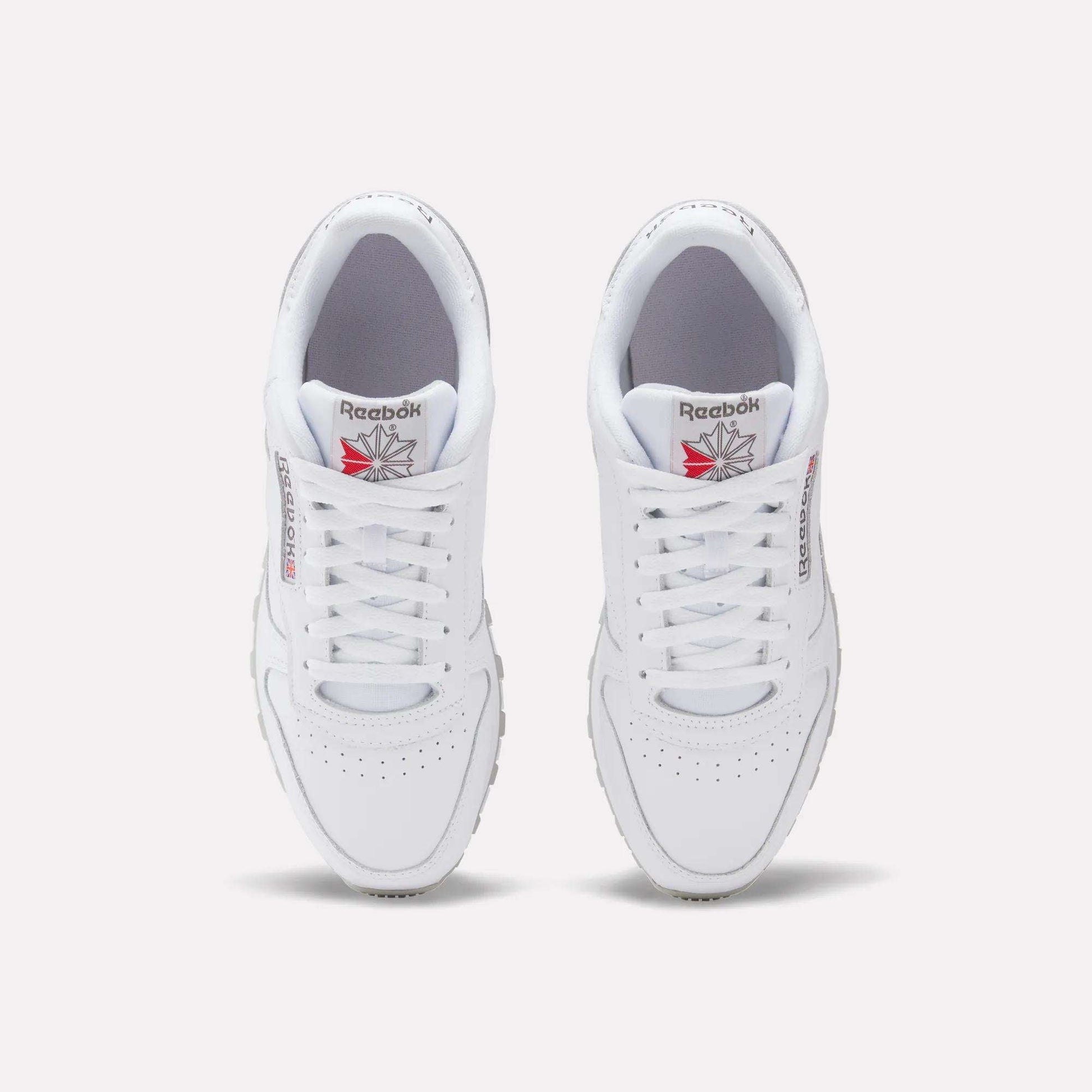 A top-down view of Reebok Classic Leather Shoes, featuring white uppers, laces, and the Reebok logo with red detailing on each tongue.
