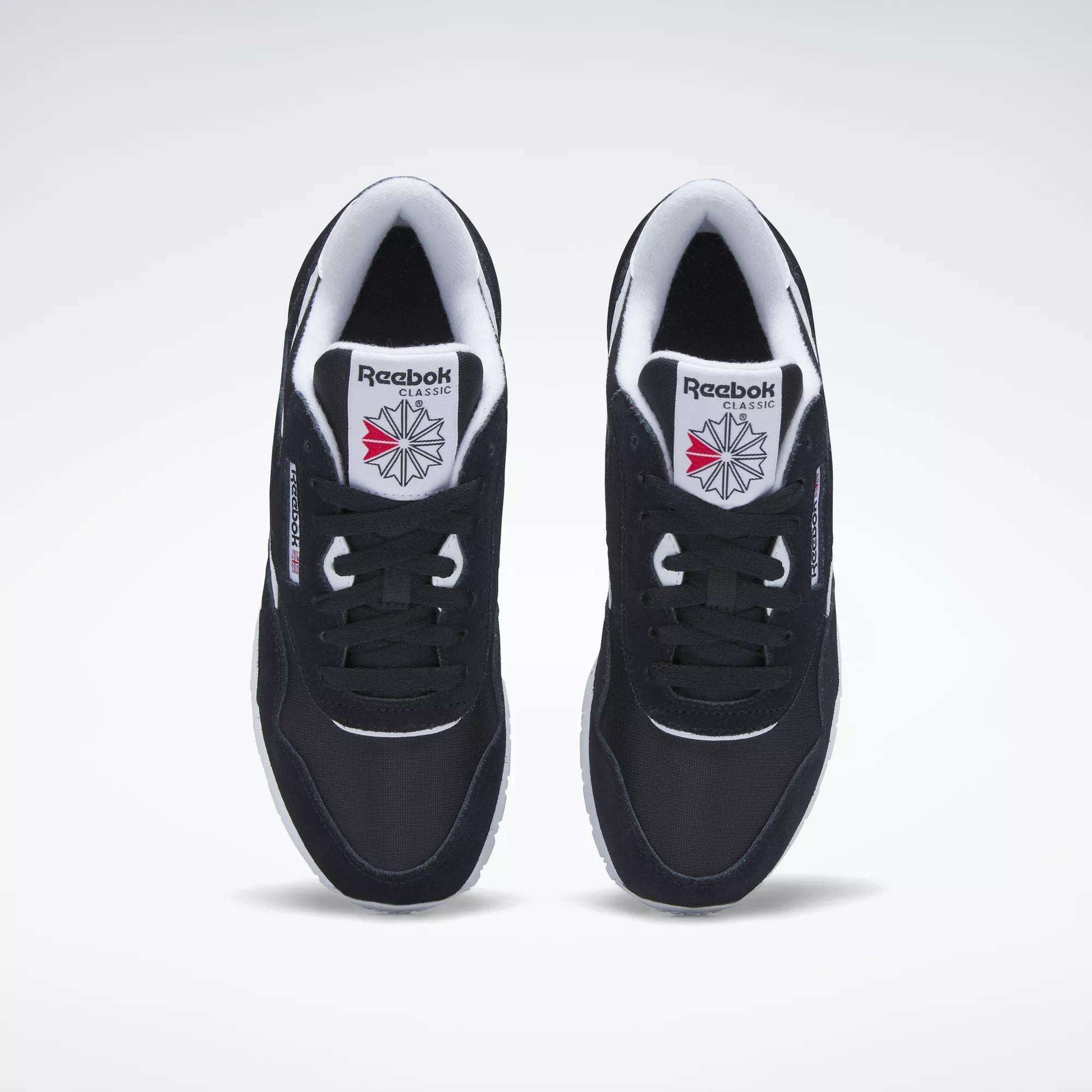 A pair of Women's Classic Nylon Shoes by Reebok in black, viewed from above. They feature white midsoles, classic Reebok branding, and a red and gray star logo on the tongues, displayed on a plain white background.