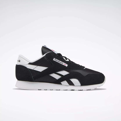 Side view of Reebok Women's Classic Nylon Shoes in black and white, featuring a white sole, black upper, and white details. These iconic sneakers are a versatile everyday choice for women, set against a simple light background.
