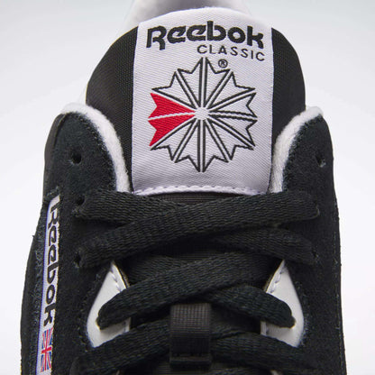 Close-up of Men's Classic Nylon Shoes by Reebok in black and white, featuring the Reebok logo on the tongue, black laces, and a UK flag patch—ideal everyday sneakers with timeless style.