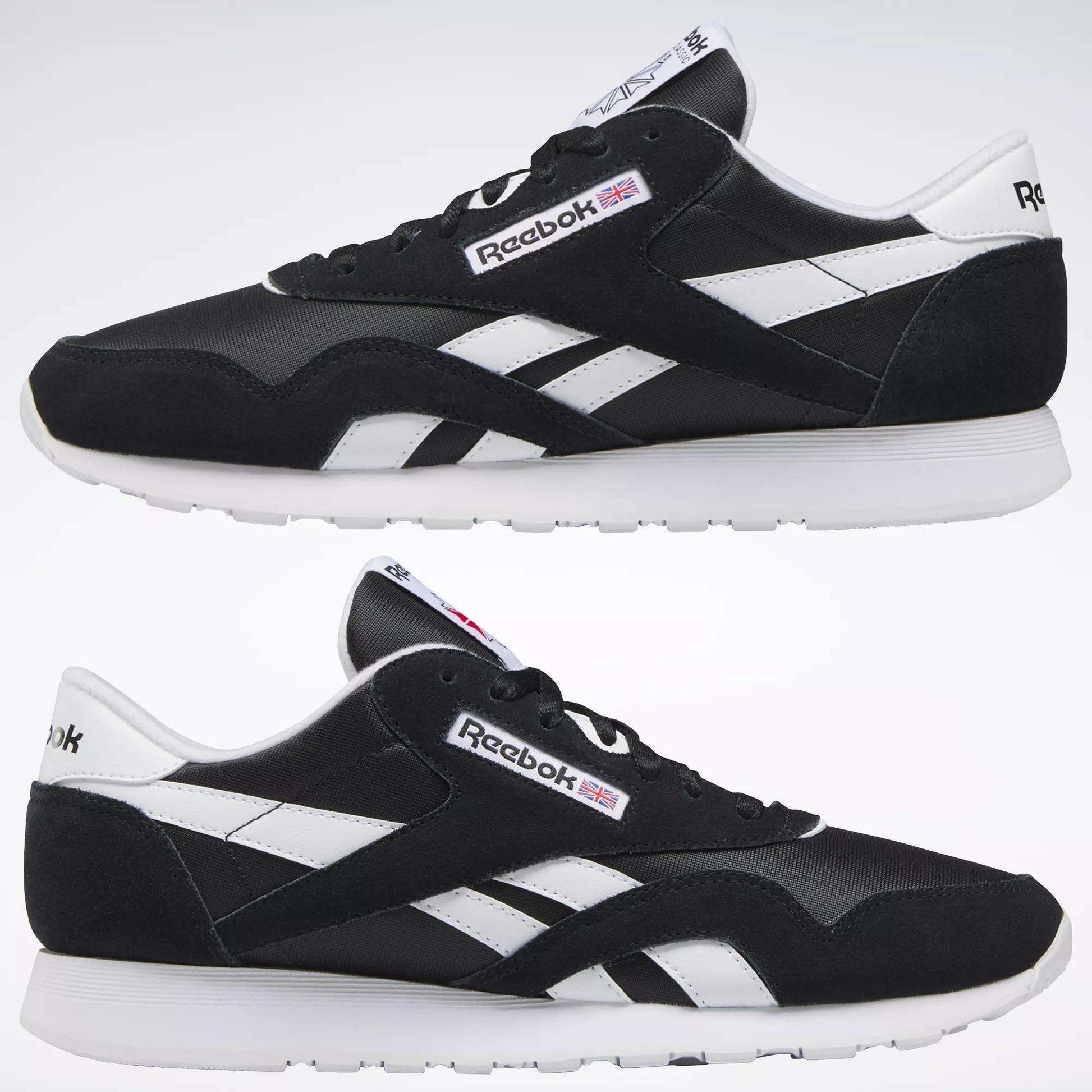 Two black Reebok Men's Classic Nylon Shoes with white soles and side stripes are shown side by side on a plain background. The Reebok logo and a small UK flag appear on the sides and tongue of these classic sneakers.