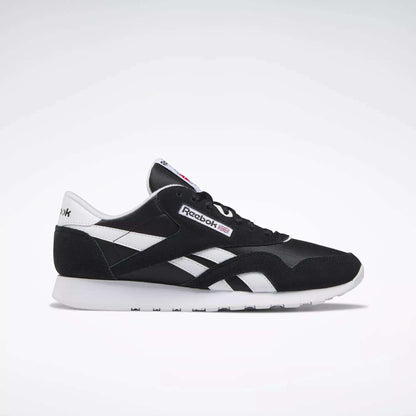 The Reebok Men's Classic Nylon Shoes in black and white feature white side stripes, a white sole, and signature Reebok logos—ideal everyday sneakers for men—displayed in a side profile on a plain light background.