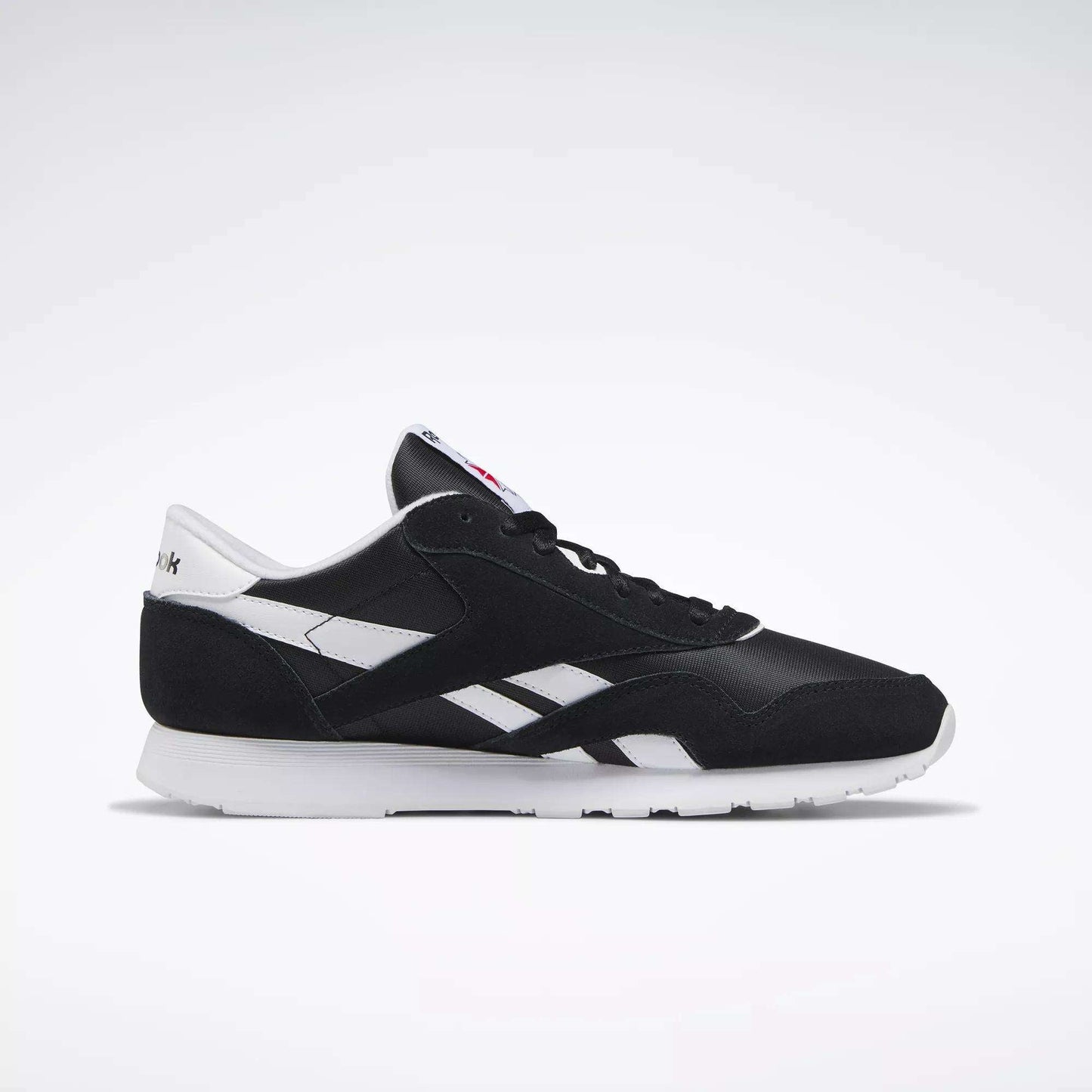 The Reebok Men's Classic Nylon Shoes feature a black and white design with a white sole, side detailing, and heel tab, showcased on a plain light background.