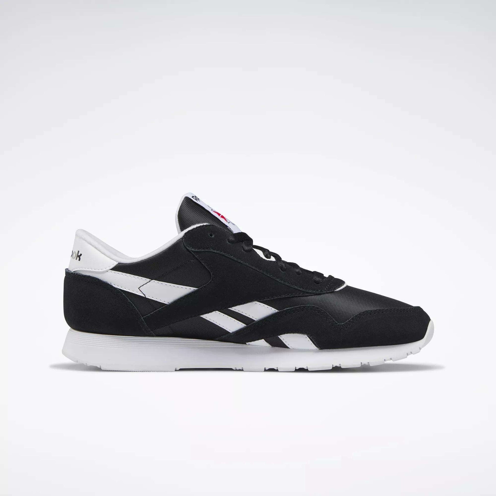 The Reebok Men's Classic Nylon Shoes feature a black and white design with a white sole, side detailing, and heel tab, showcased on a plain light background.