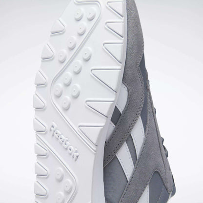 Close-up of the underside of Reebok Men's Classic Nylon Shoes in gray and white, highlighting the textured white rubber sole with Reebok logo, gray nylon upper, and iconic side stripes—timeless sneakers for everyday wear.