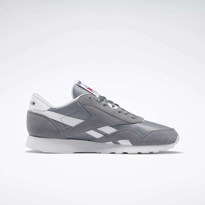 The Reebok Men's Classic Nylon Shoes in gray and white feature a nylon upper with leather accents, white sole, and laces; a timeless choice for everyday wear, shown from the side on a plain light background.