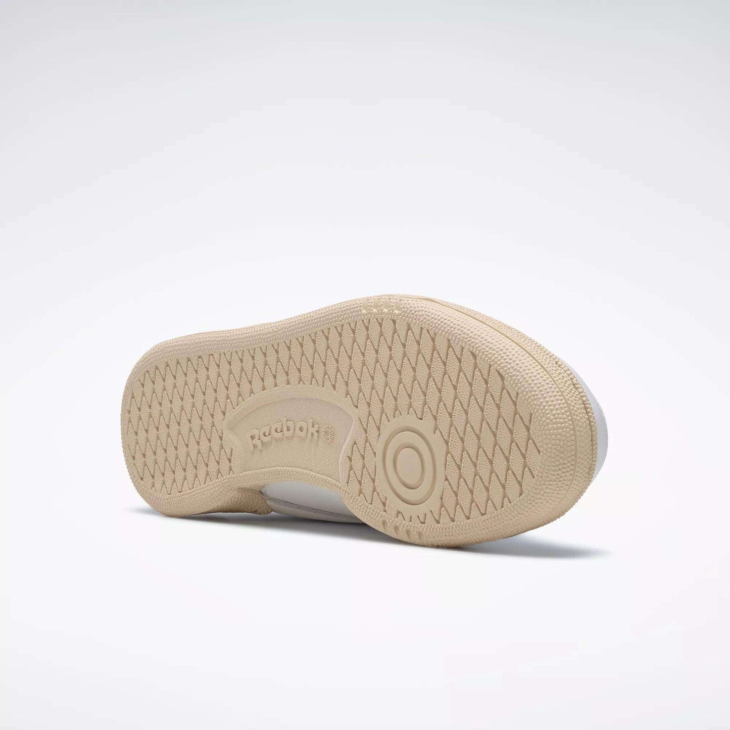 The Reebok Women's Club C 85 Vintage Shoes, shown in beige on a light background, feature a textured herringbone rubber outsole with circular treads and Reebok branding—making them an excellent choice in women's tennis footwear.