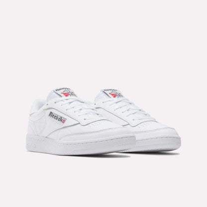 A pair of Reebok Club C 85 Shoes in white leather with low tops, showing the Reebok logo and Union Jack on the side. Inspired by classic tennis styles, displayed against a plain white background.