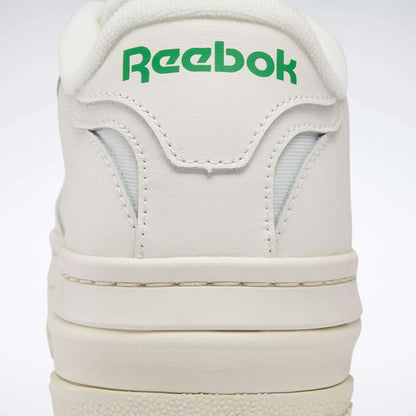 Close-up of the heel on Women's Club C Extra Shoes by Reebok, featuring green Reebok branding on the back, detailed stitching, and a glimpse of the white platform midsole.