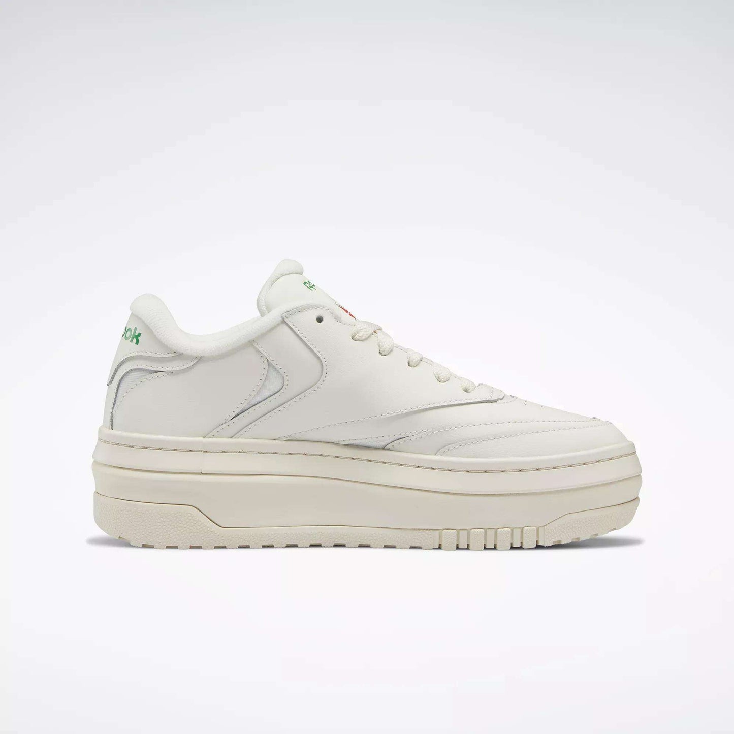 The Reebok Women’s Club C Extra Shoes feature a white upper, thick platform midsole, subtle stitching, and green Reebok branding on the tongue and heel—ideal for elevating your women’s shoe collection. Shown in side profile on a plain light background.