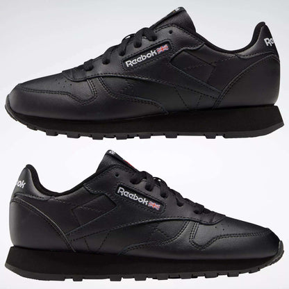 The Reebok Classic Leather Shoes - Big Kids are black sneakers with a classic design, black soles and laces, plus the Reebok logo and UK flag on the side and tongue.