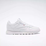 The Reebok Classic Leather Shoes - Big Kids feature an all-white, low-top design with lace-up closure, subtle side branding, and a flat rubber sole—perfect for adding minimalist style to any junior boys' shoe collection.