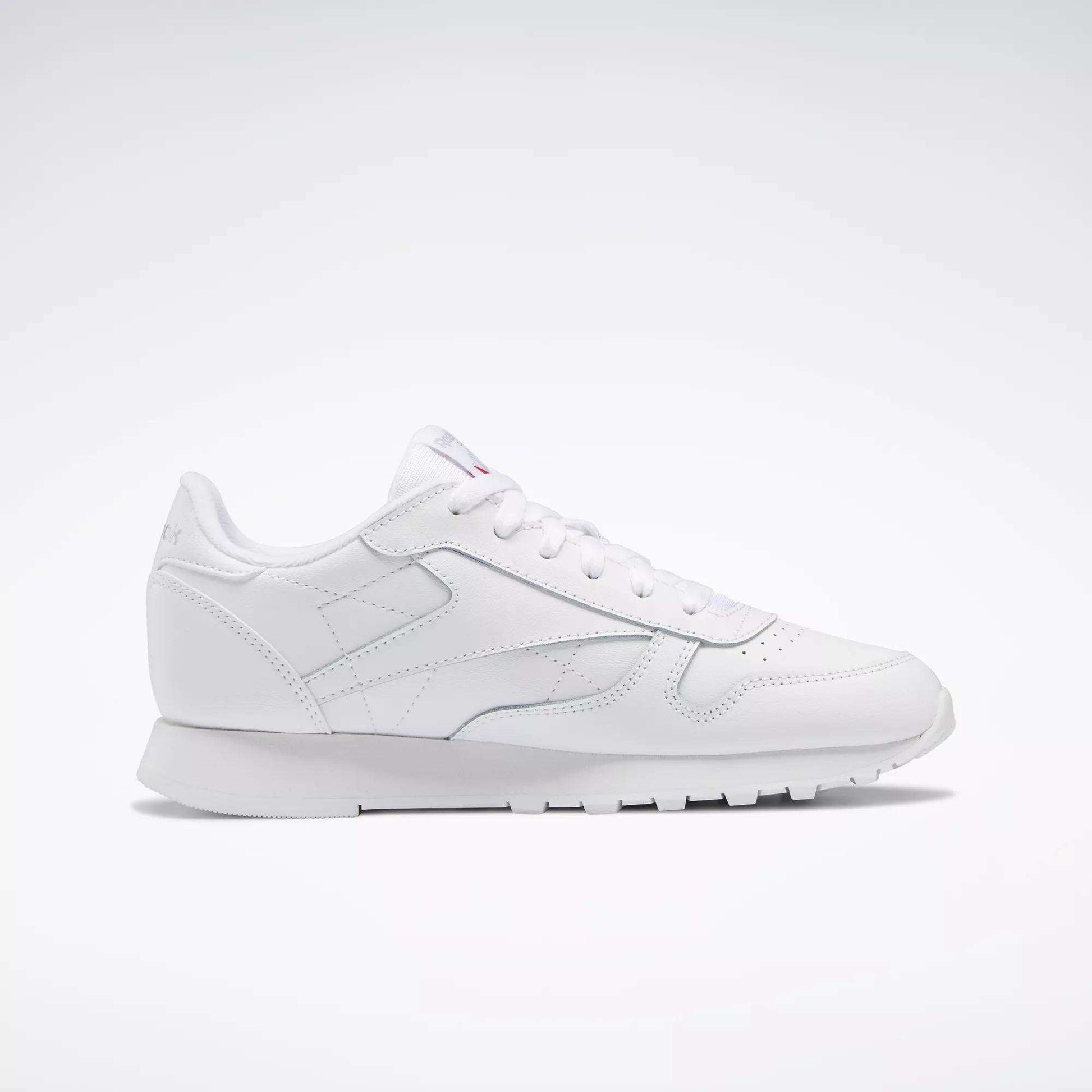 Reebok Classic Leather Shoes - Big Kids: A white, low-profile sneaker with lace-up closure and textured sole, ideal for junior boys—displayed on a plain light background.