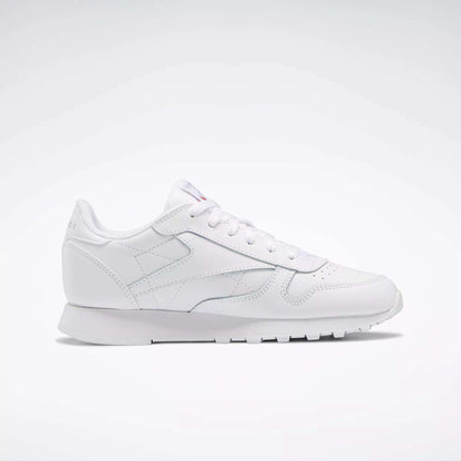 Reebok Classic Leather Shoes - Big Kids: A white, low-profile sneaker with lace-up closure and textured sole, ideal for junior boys—displayed on a plain light background.