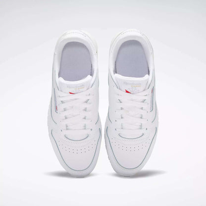 A pair of Reebok Classic Leather Shoes for big kids in white, viewed from above with both shoes side by side, laces tied, and subtle branding on the tongues—a timeless design.