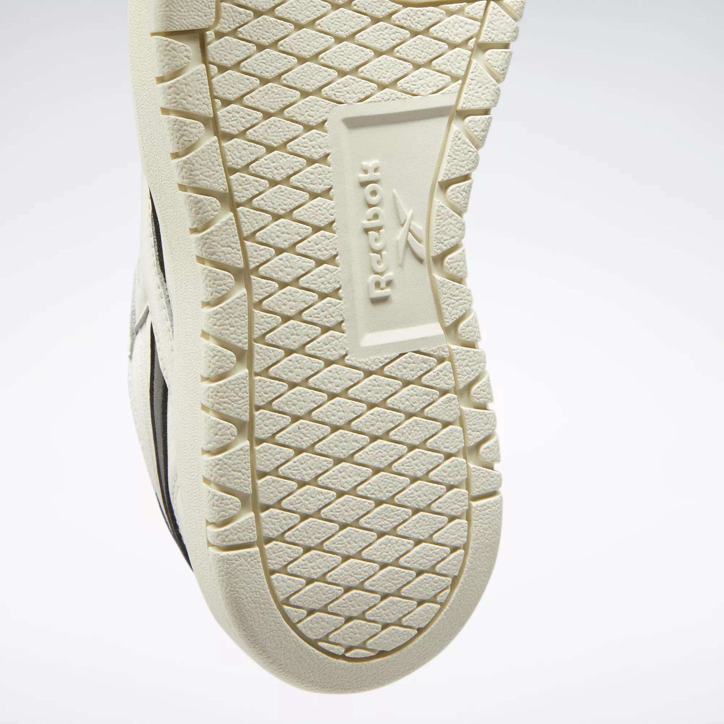 Close-up of the textured sole on Reebok Women's Club C Double Revenge Shoes, showcasing the embossed Reebok name and logo at the center with a hexagonal tread—ideal for fans of court-inspired styles.