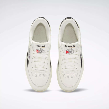 Top-down view of Women's Club C Double Revenge Shoes by Reebok, featuring black accents, double outsole, Reebok logos on the tongue, and perforated toe area, displayed side by side on a light background.