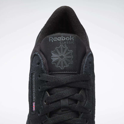 A close-up of Reebok Men's Classic Nylon Shoes features a black nylon upper, black laces, Reebok logo and starburst on the tongue, and a small UK flag on the side—timeless sneakers from Reebok.