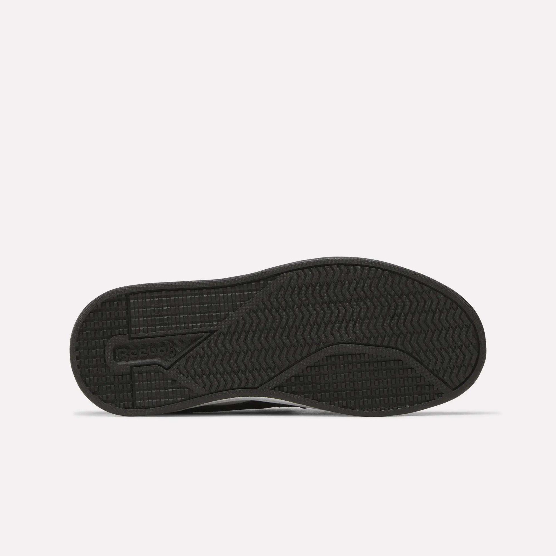 The image shows the sole of a black Kids' Reebok Royal Prime 2 Shoe featuring textured grip patterns and the Reebok logo on the left side, set against a plain white background.