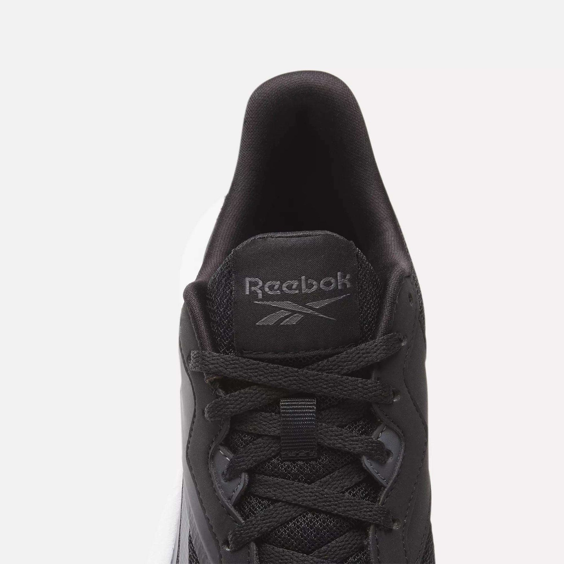 Top view of a black Women's Energen Lux Running Shoe by Reebok with black laces, mesh fabric, and a gray Reebok logo on the tongue. Set against a plain white background.