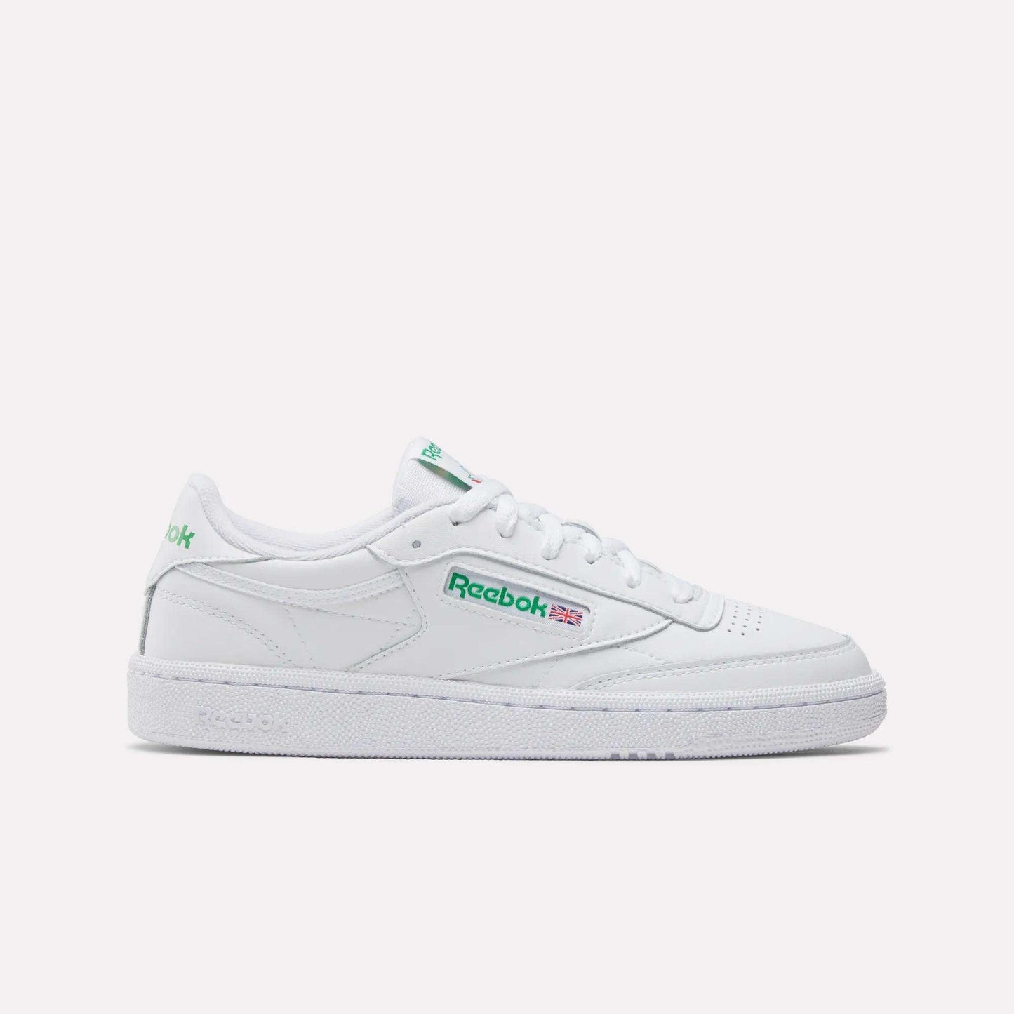 The Women's Club C 85 Shoes by Reebok feature a white low-top design with green branding and a flat rubber sole, displayed in side profile on a plain white background—ideal for women's shoe collections.
