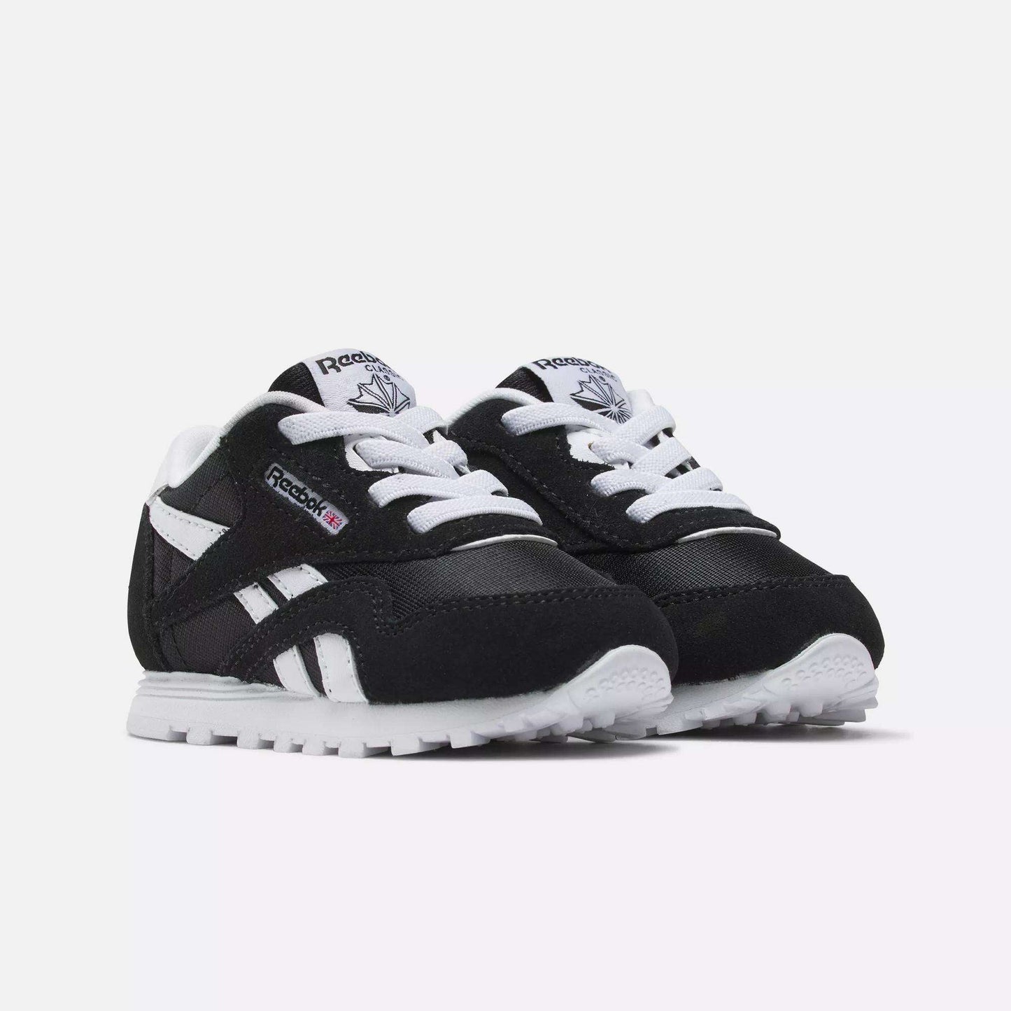 Reebok Kids' Classic Nylon Shoes for toddlers in black and white, featuring a suede and nylon upper, white laces and soles, plus Reebok logos on the side and tongue, are shown against a plain white background.