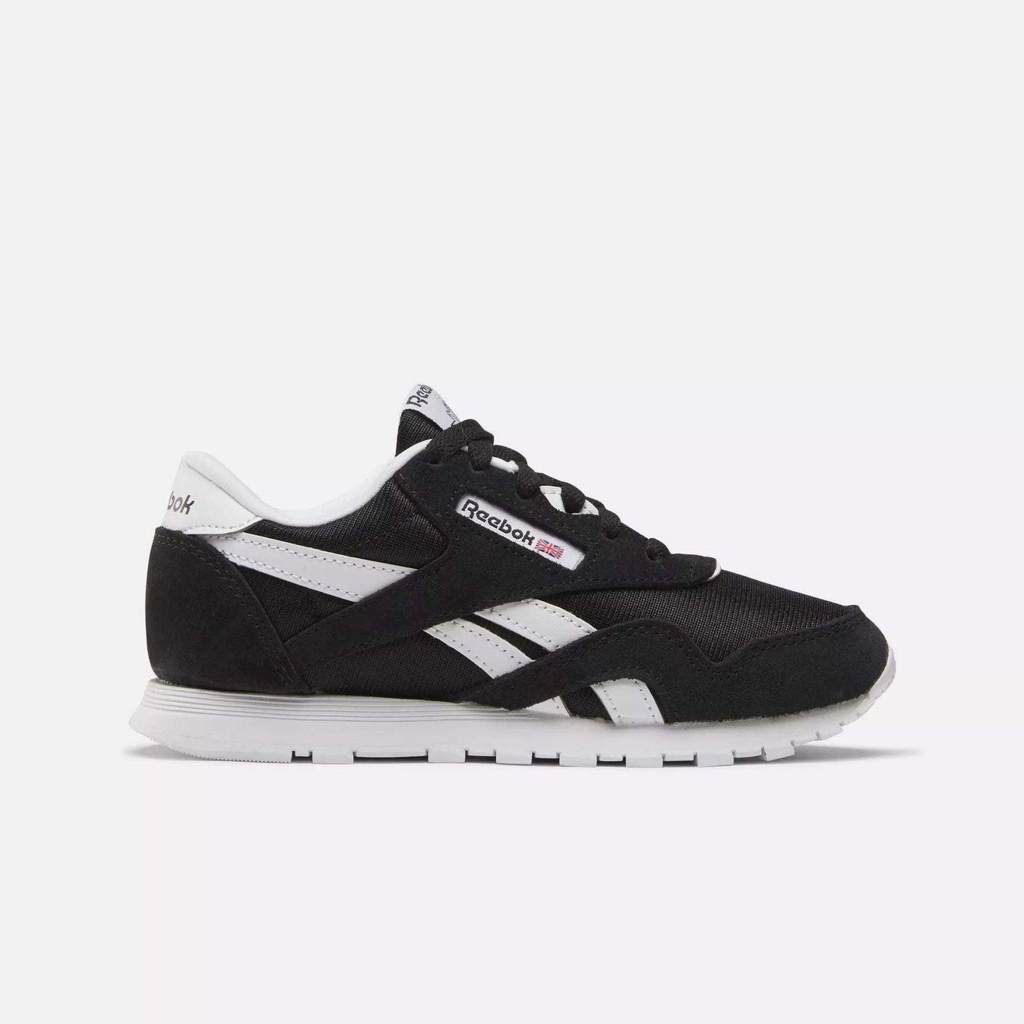 Side view of Kids' Classic Nylon Shoes - Preschool by Reebok in black with white accents, iconic logo, and stripes. Designed for boys, these sneakers offer lightweight cushioning, a white sole, and black laces on a light background.
