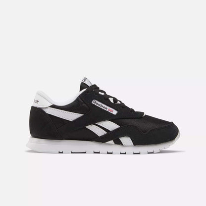Side view of Kids' Classic Nylon Shoes - Preschool by Reebok in black with white accents, iconic logo, and stripes. Designed for boys, these sneakers offer lightweight cushioning, a white sole, and black laces on a light background.