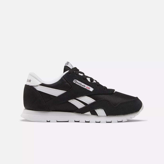 Side view of Kids' Classic Nylon Shoes - Preschool by Reebok in black with white accents, iconic logo, and stripes. Designed for boys, these sneakers offer lightweight cushioning, a white sole, and black laces on a light background.