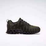 The Reebok Men's ZigWild Trail 6 Shoes feature a dark green and black mesh upper, wavy segmented sole, and lace-up closure for enhanced cushioning. Shown in side profile on a light background, they blend trail-inspired style with top performance.
