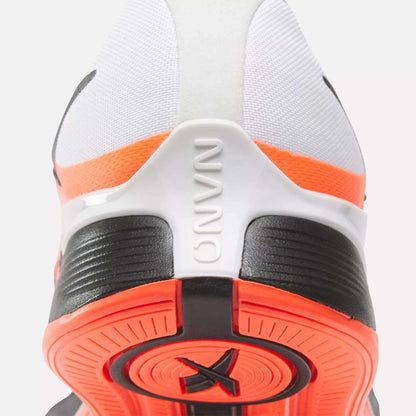 Close-up of the back of a white, black, and orange Reebok Women's Nano X4 Training Shoe shows the heel, textured sole, and embossed NANO on the heel tab. Enjoy superior support with these lightweight training shoes.