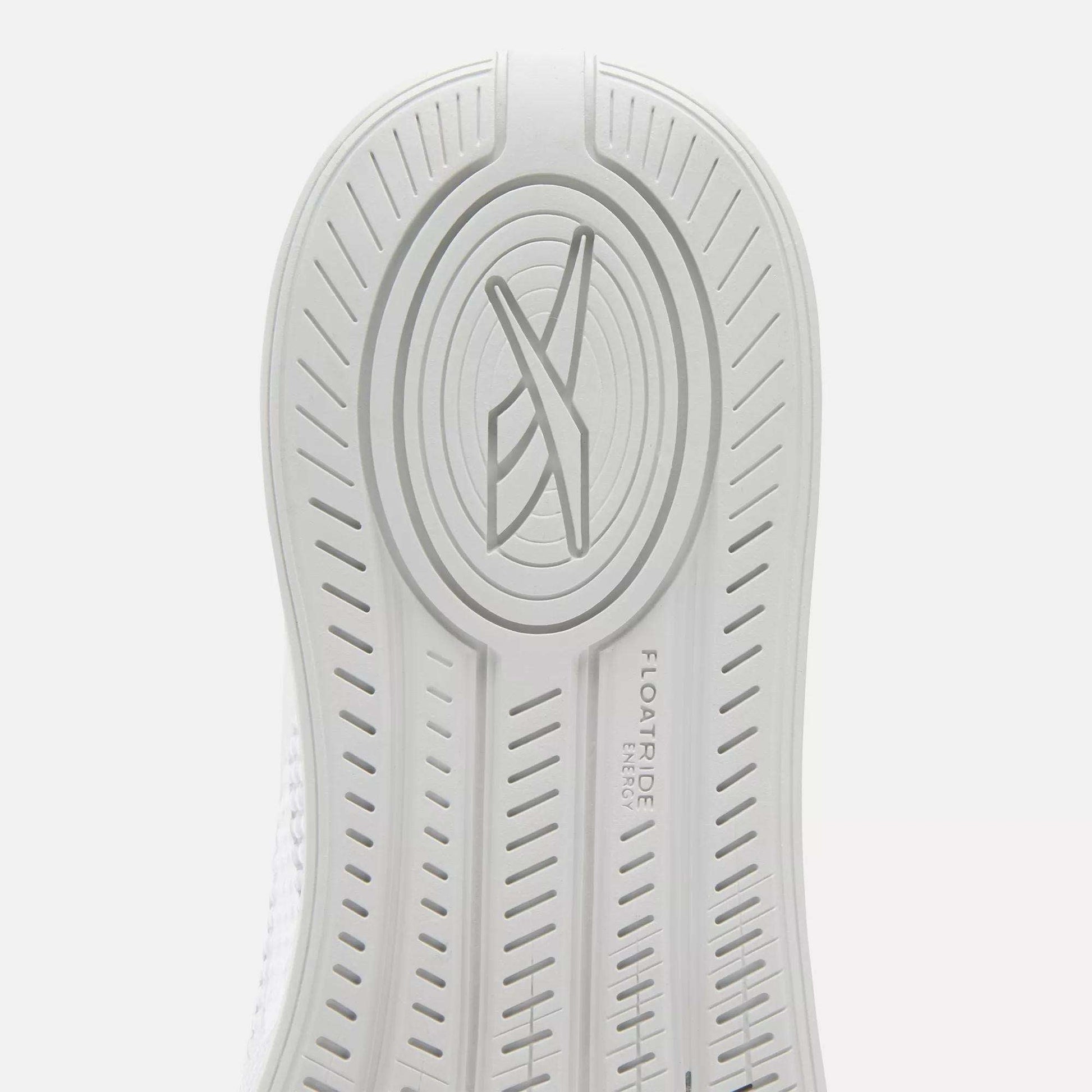 Close-up of the white sole on Reebok Nano X4 Women's Training Shoes featuring an oval pattern, stylized X logo at the center, and FLOATRIDE ENERGY text engraved beside textured grip lines.