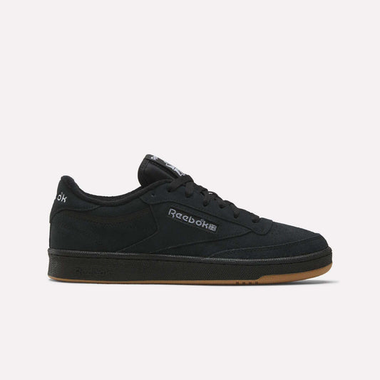 The Reebok Club C 85 Shoes feature a low-profile black suede upper, black sole, gum outsole, and a white Reebok logo on the side, shown against a plain light background.