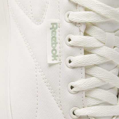 Close-up of Reebok Active Lite Shoes highlighting the iconic logo tag, detailed stitching, and crisp white laces—these minimalist sneakers combine classic design with modern Reebok style.