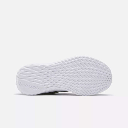 Bottom view of Reebok Rush Runner Slip-On Shoes for little kids, showing a textured, diamond-patterned sole for traction and lightweight cushioning. The embossed Reebok logo appears near the heel. Background is plain white.