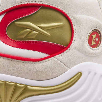 Close-up of the Reebok Answer III Basketball Shoes, featuring a gold Reebok logo, red and gold accents, white midsole, and an embossed circular emblem with a red 3 on light suede—an iconic Allen Iverson style.
