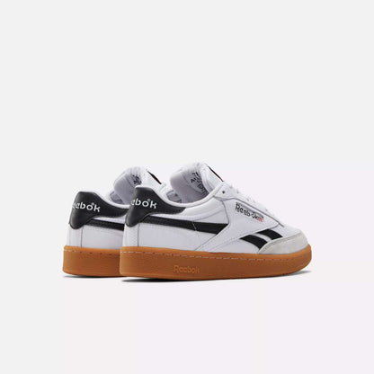 Two white Reebok Men's Club C Revenge Vintage Shoes with black accents and gum soles are displayed side by side on a white background. The classic Reebok logo appears on the side and heel, highlighting these timeless casual sneakers.
