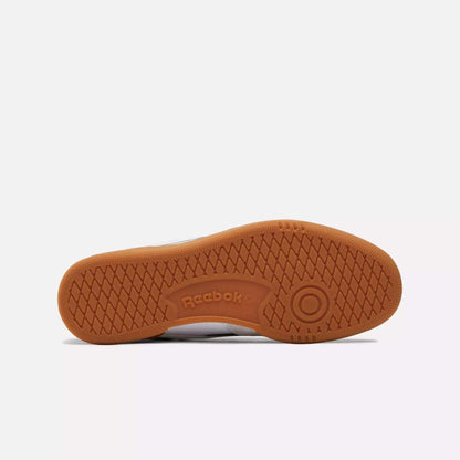 The image shows the sole of the Men's Club C Revenge Vintage Shoes by Reebok, featuring a gum rubber herringbone tread and the embossed Reebok logo—highlighting retro skate style.