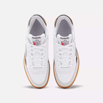 A pair of Men's Club C Revenge Vintage Shoes by Reebok in white leather with brown gum soles, shown from above. Features include perforated toe boxes, the Reebok logo, and a red and grey star emblem on the tongue.
