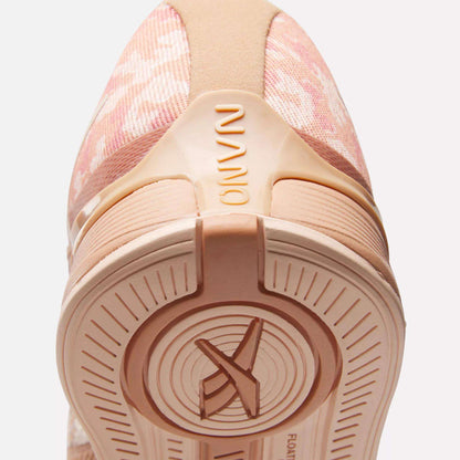 Close-up of the heel and sole of Reebok Women's Nano X4 Training Shoes in pink with beige accents. "NANO" appears on the heel, and the lightweight, breathable sole features circular patterns with an X design at the center.