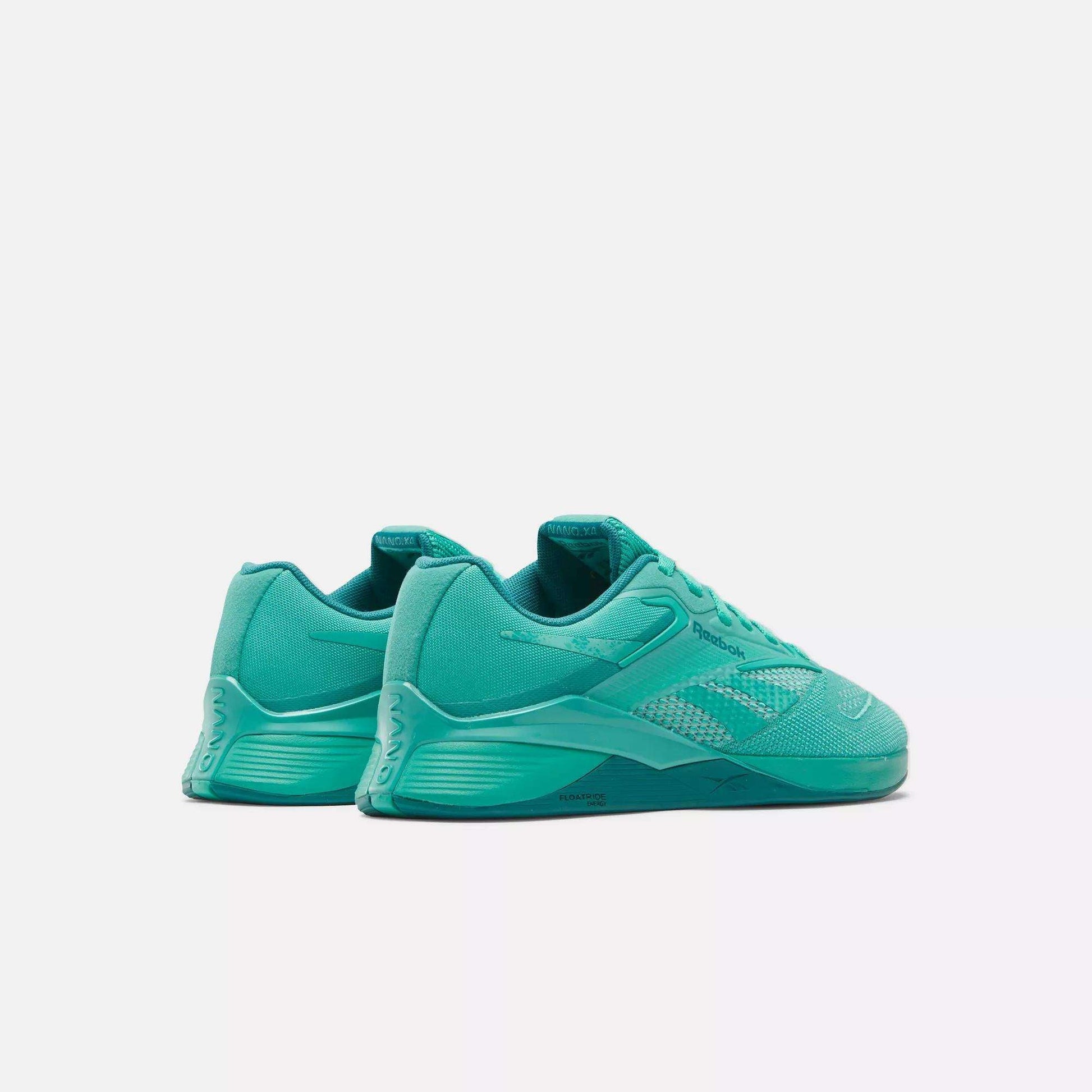 The Reebok Women's Nano X4 Training Shoes in teal are shown angled to display the side and back, featuring mesh and synthetic details, lace-up closure, and a textured sole—lightweight trainers on a plain white background.