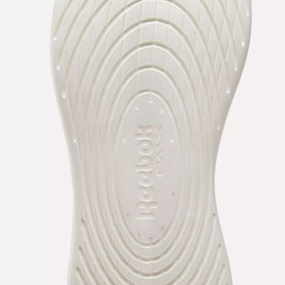 Close-up of the white sole on Reebok Active Lite Shoes, showcasing concentric oval grooves and embossed "Reebok" branding at the center.