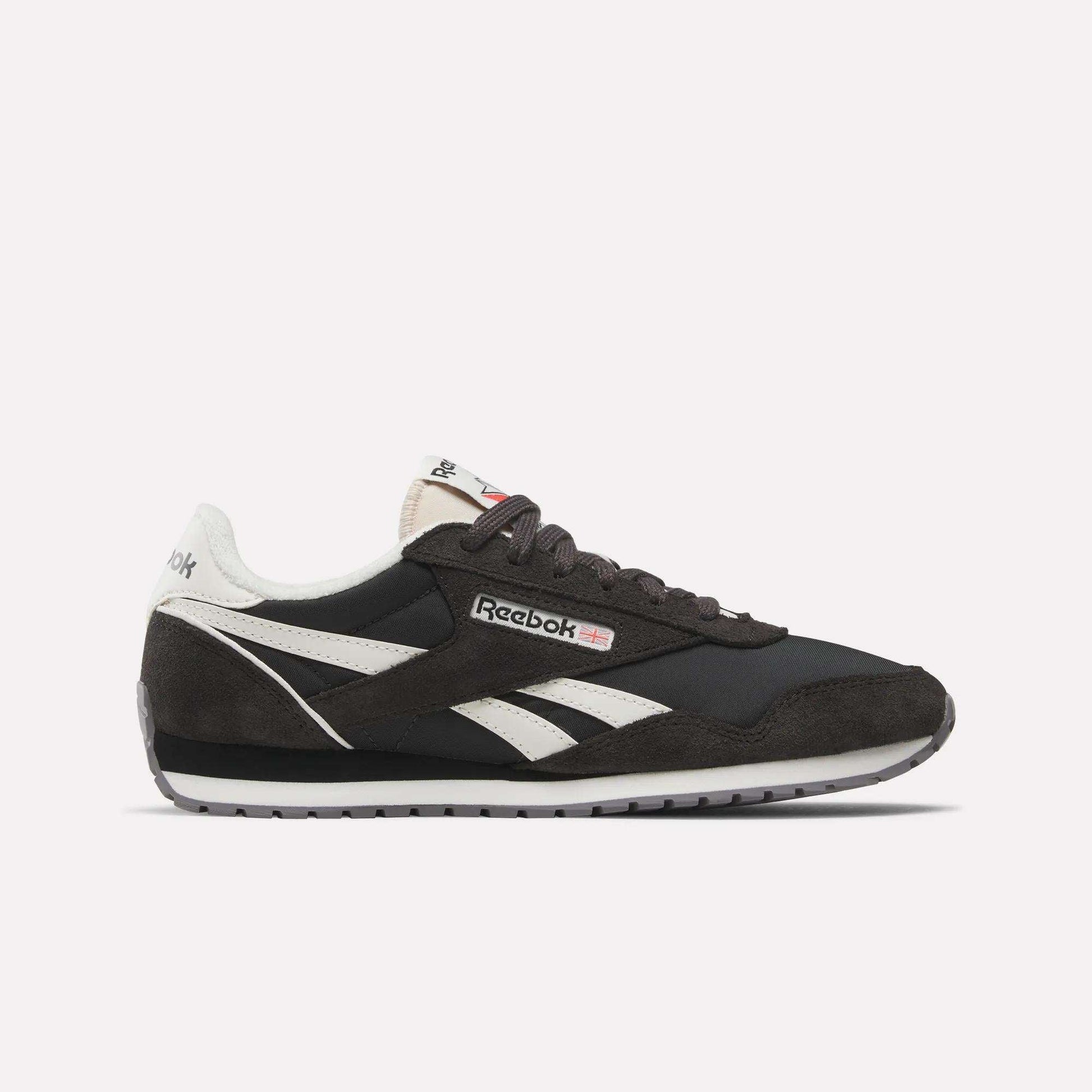 The Reebok Women's Classic AZ Shoes feature black and white suede and leather details, signature white side stripes, a black sole, and the Reebok logo on the side and tongue—all shown against a plain white background.