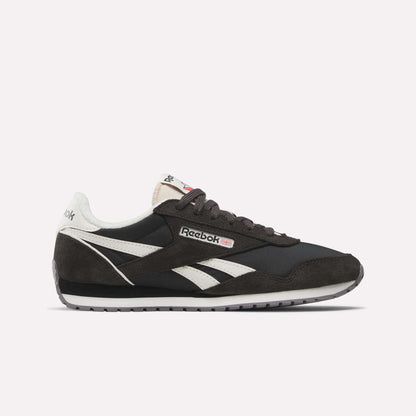 The Reebok Women's Classic AZ Shoes feature black and white suede and leather details, signature white side stripes, a black sole, and the Reebok logo on the side and tongue—all shown against a plain white background.
